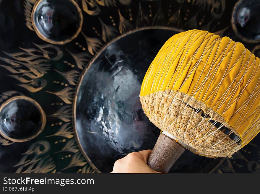 Hand hit big gong in temple