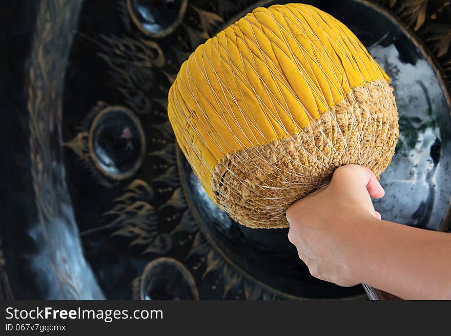 Hand hit big gong in temple