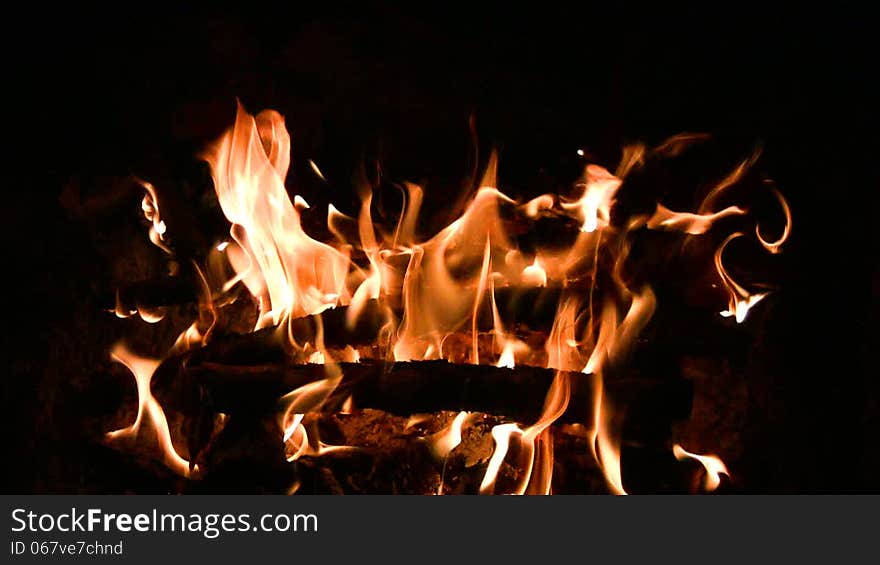 Bright orange flames dancing on the black night background. Bright orange flames dancing on the black night background