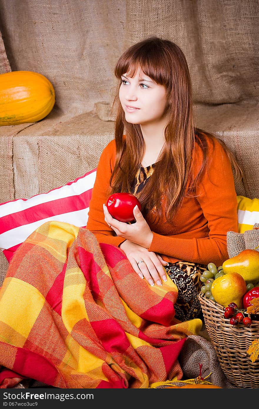 Young pretty woman holds an apple, smile and looks towards