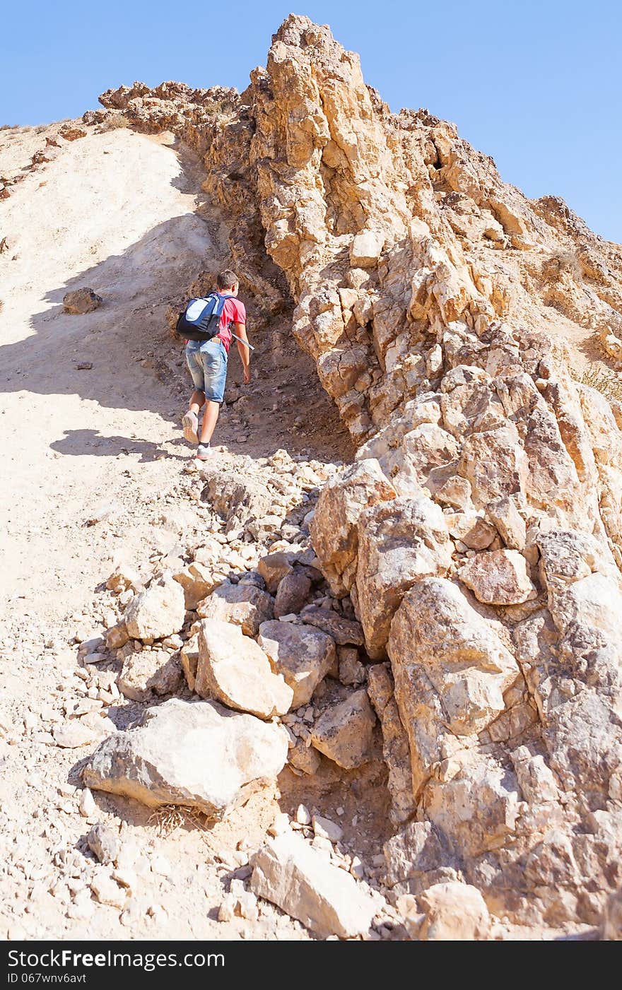 Guy climbs on a low hill summer day