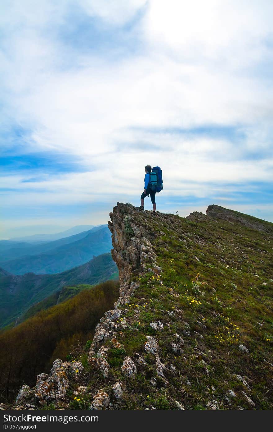 Sporty woman with backpack on top of the rock. Sporty woman with backpack on top of the rock