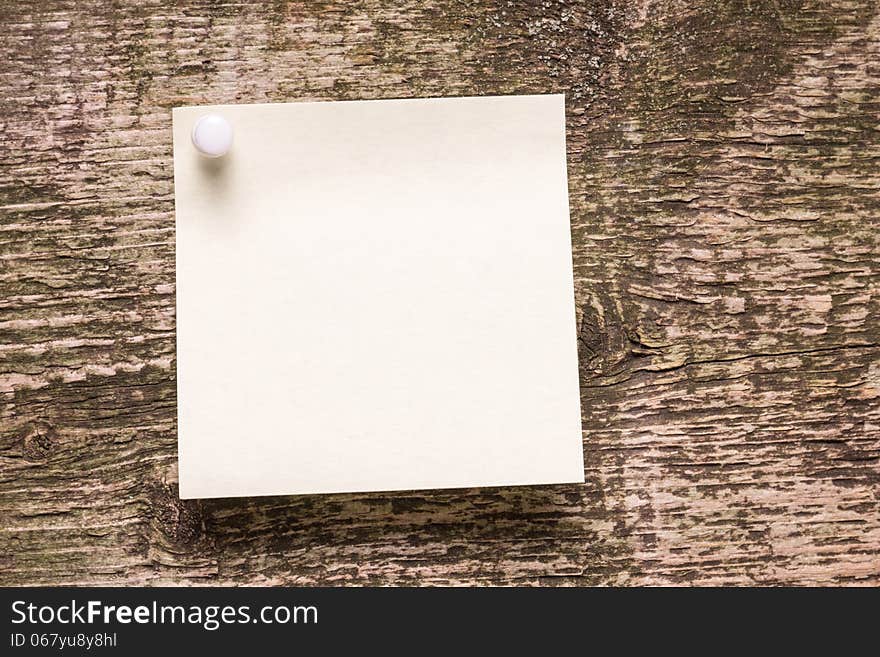 Yellow paper sticker on wood background