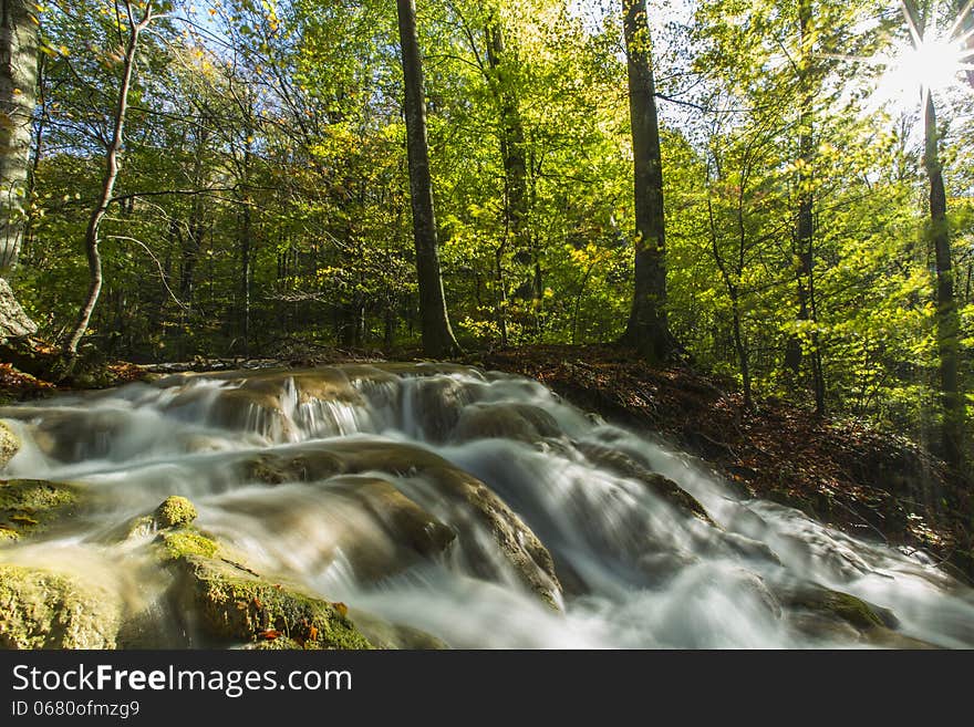 Beautiful autumn foliage, waterfalls and reflection patterns in mountain stream in the forest. Beautiful autumn foliage, waterfalls and reflection patterns in mountain stream in the forest