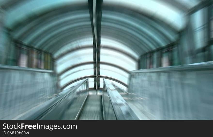 Videography is made from the steps of a moving escalator under the glass roof. Zoom Blur. Videography is made from the steps of a moving escalator under the glass roof. Zoom Blur