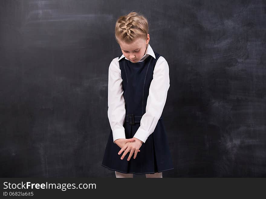 Sad Little Schoolgirl Near Blackboard