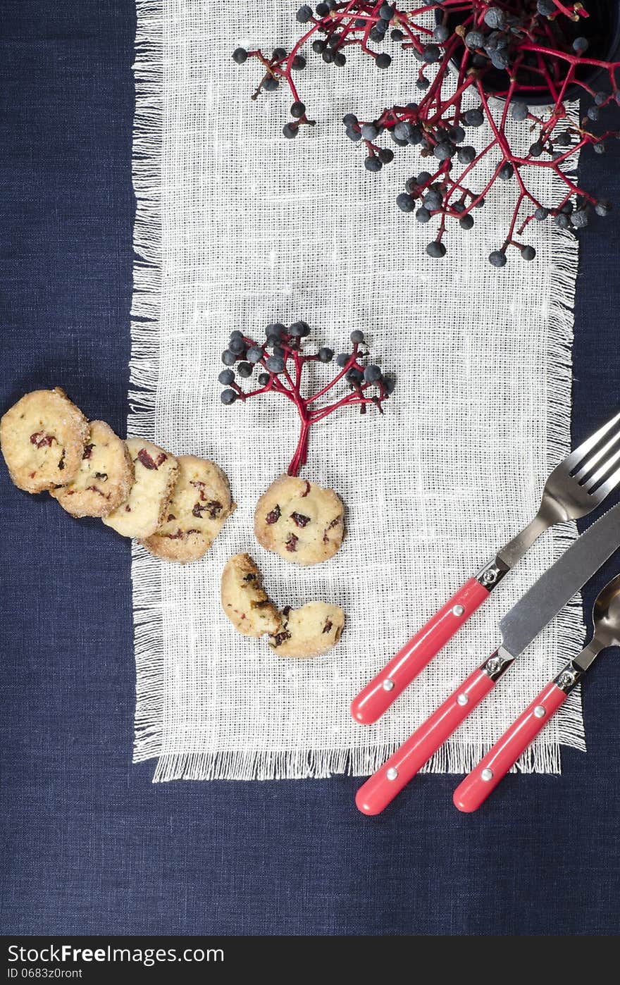 Porcelain dishes and cookies with cranberries. From series Playing with Color