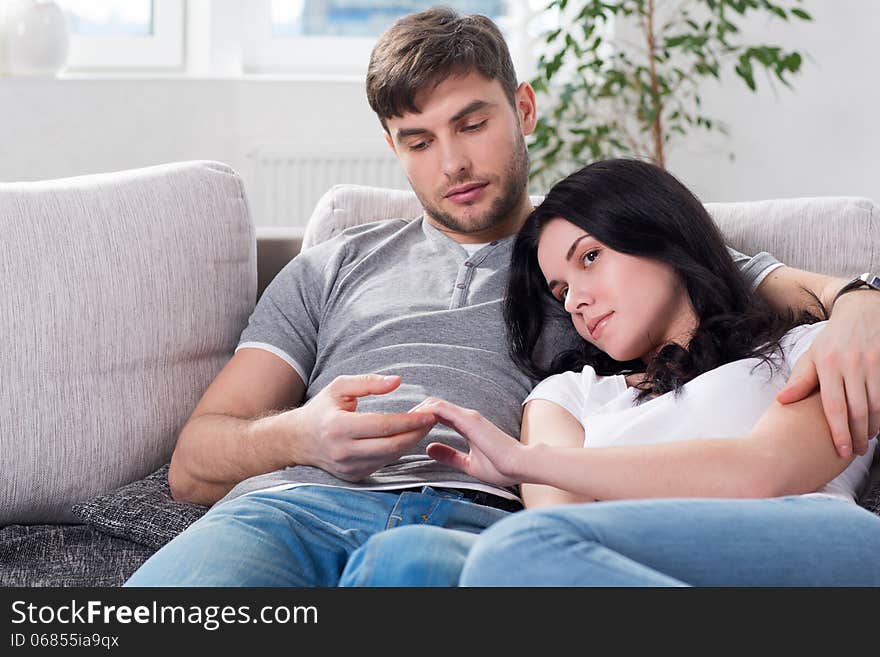 Young couple are sitting down on a couch