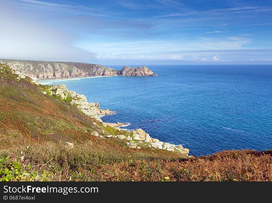 Coast of Cornwall England in autumn with mist and blue sky near the Minack Theatre and Porthcurno