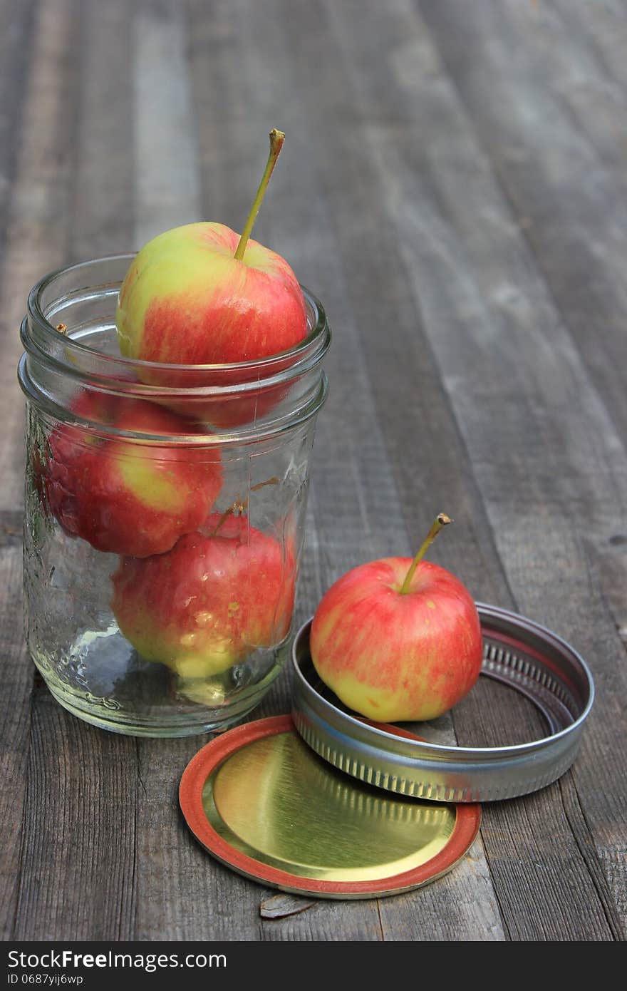 Crabapples in a Sealer Jar on a wooden plank.