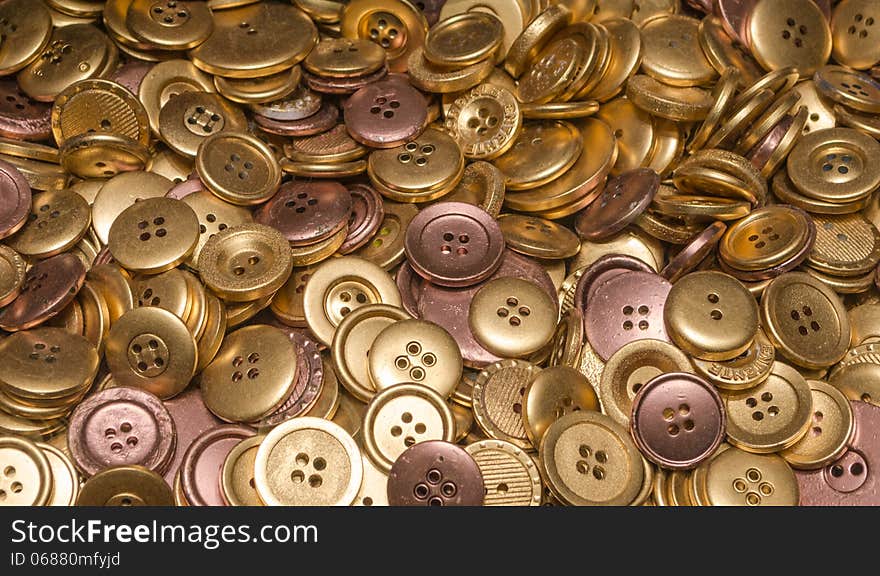 Many Gold and Brone coloured buttons. Many Gold and Brone coloured buttons