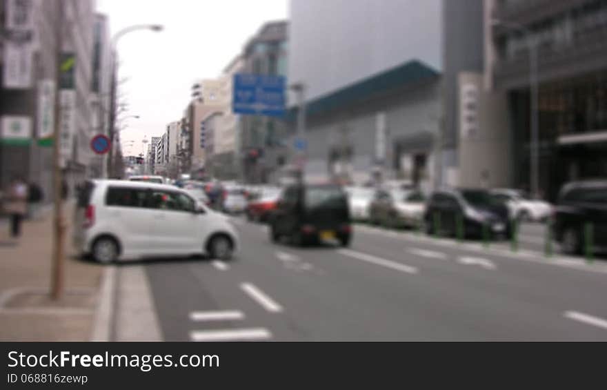 Movement of cars and pedestrians on a city street. The focus at the far end of the street. Slow motion. Movement of cars and pedestrians on a city street. The focus at the far end of the street. Slow motion