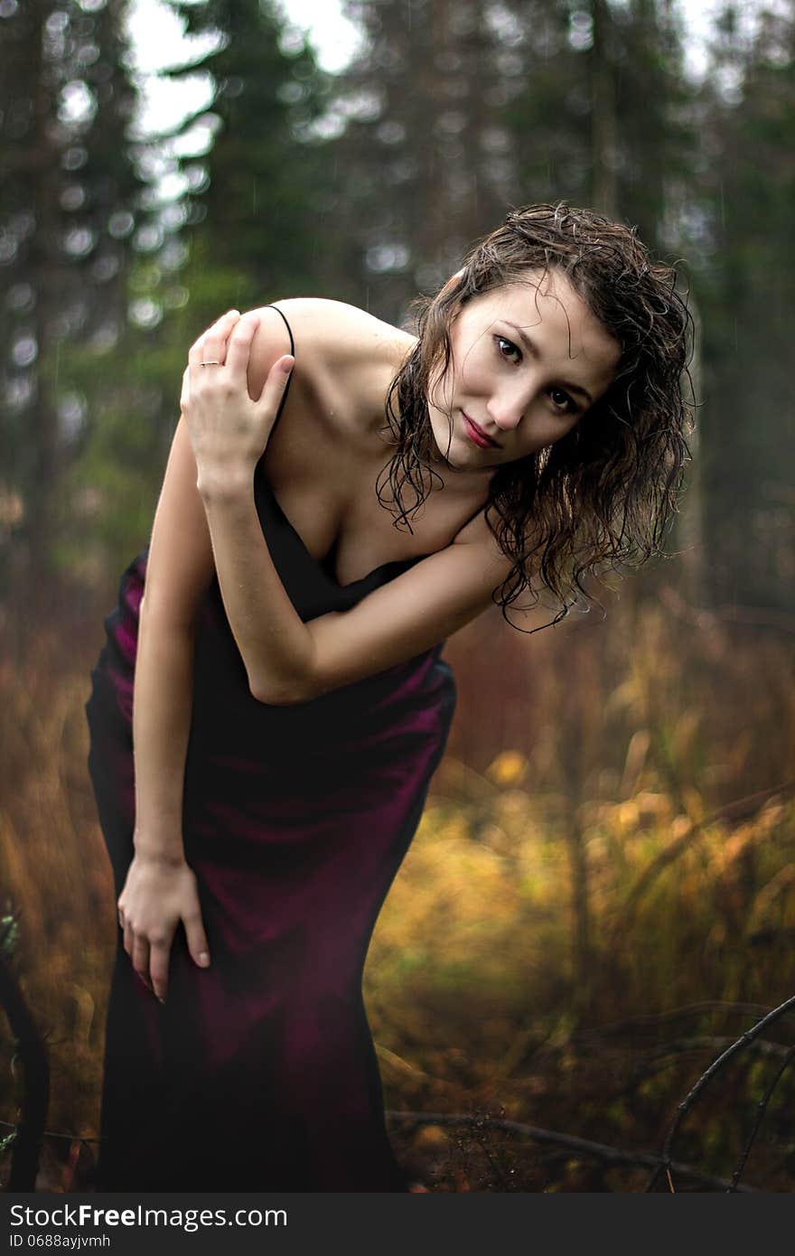 Portrait of woman in purple dress under rain