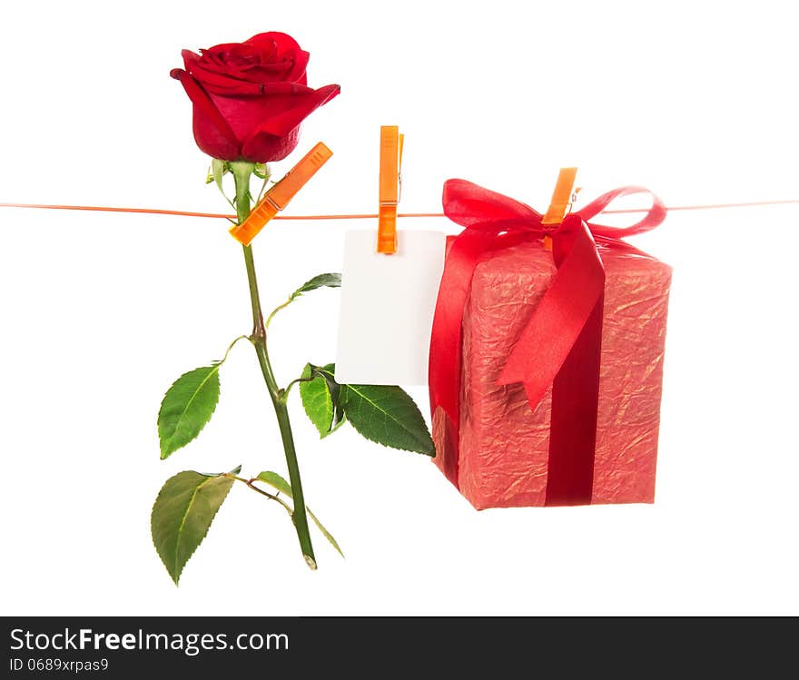 The rose, card and gift hang on rope isolated on white