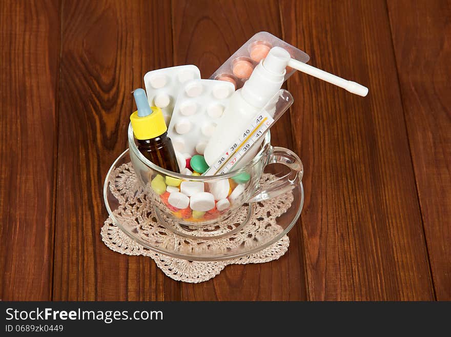 Cup with different medicines on wooden a table