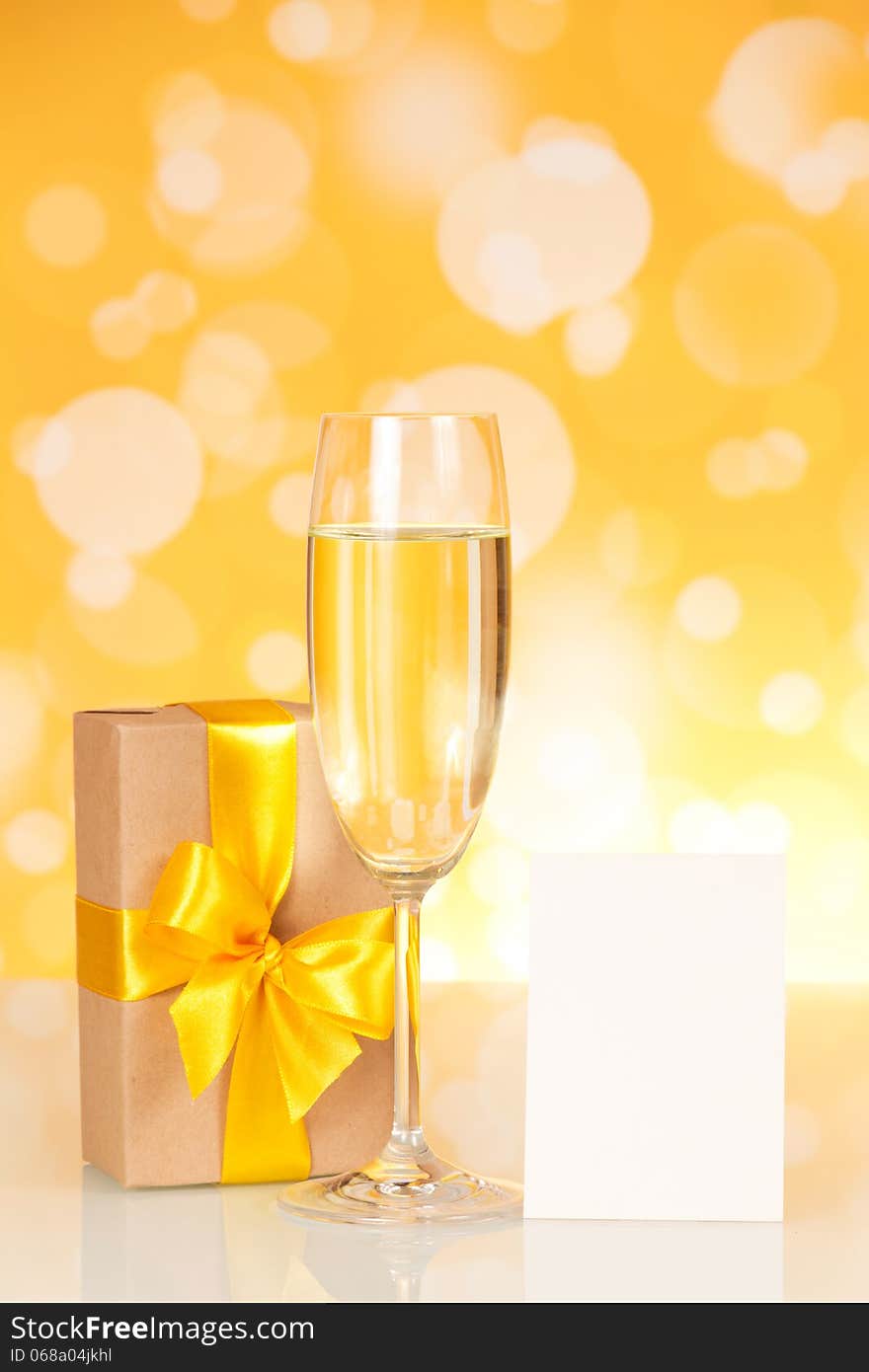 Glass with champagne, gift and empty card