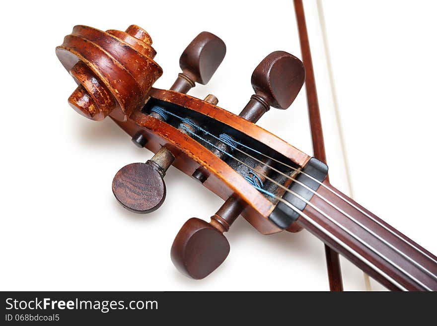 Pegbox of old threadbare antique cello with bow isolated over white background with shadow. Pegbox of old threadbare antique cello with bow isolated over white background with shadow