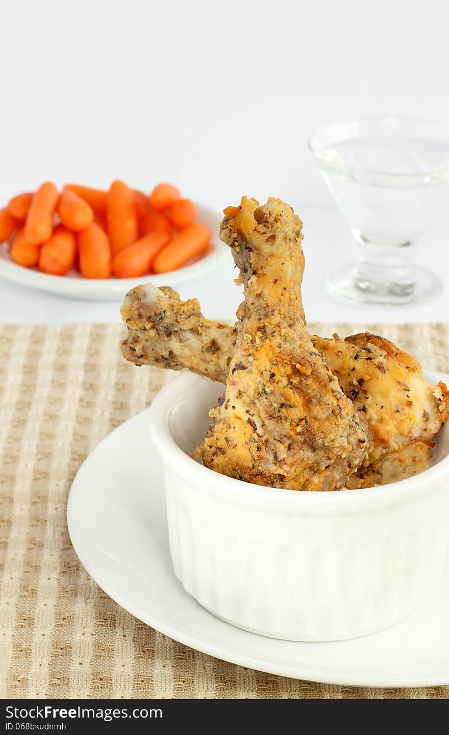 Drumsticks coated with panko crumbs and seasoning baked in the oven served with raw baby carrots. Drumsticks coated with panko crumbs and seasoning baked in the oven served with raw baby carrots