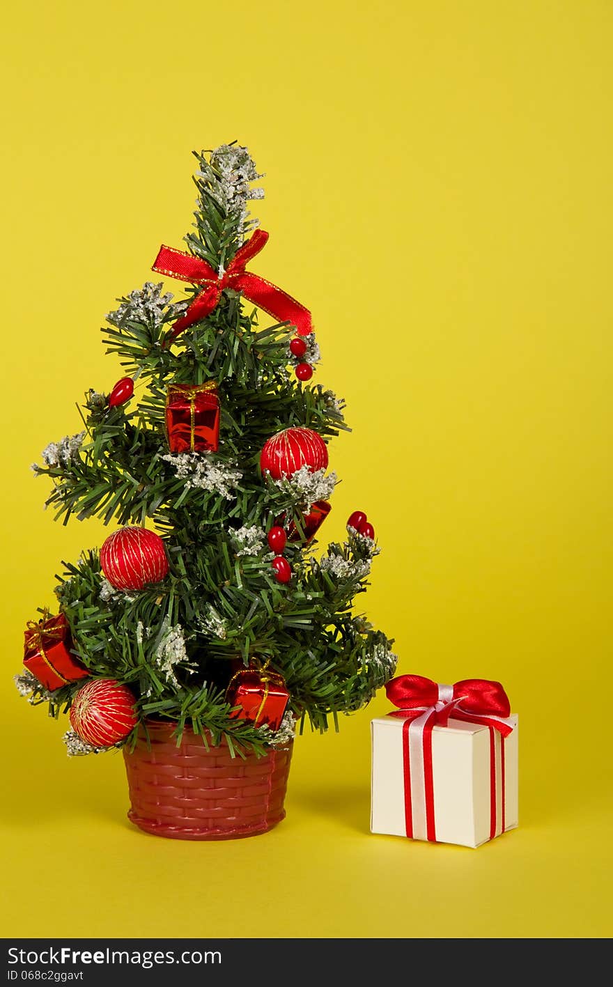 Small fir-tree in a pot with toys and gifts