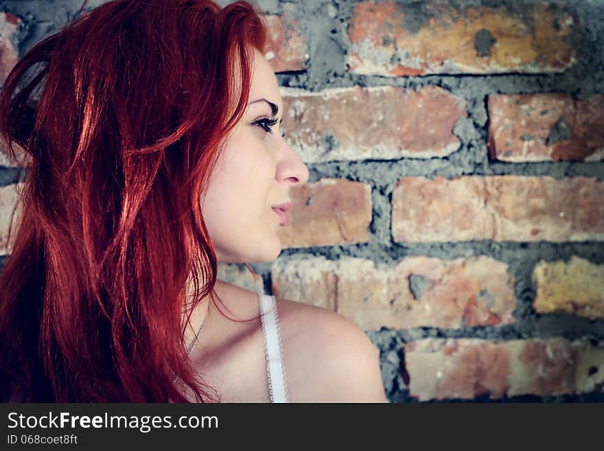 Portrait of red woman against brick wall outdoors