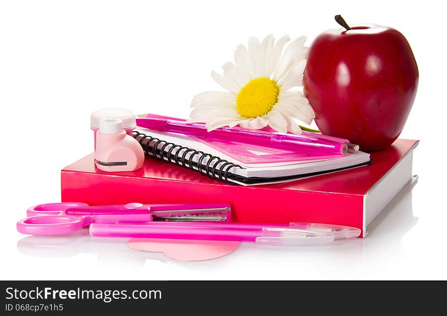 The book, a notepad, handles, pencil, scissors, a puncher, paint and red apple isolated on white. The book, a notepad, handles, pencil, scissors, a puncher, paint and red apple isolated on white