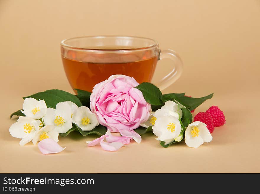 Cup of tea, branches of a jasmine and a rose on a beige background. Cup of tea, branches of a jasmine and a rose on a beige background