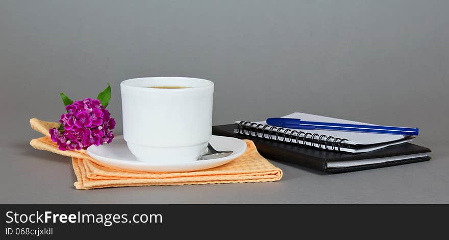 Cup of coffee with saucer, spoon and flower