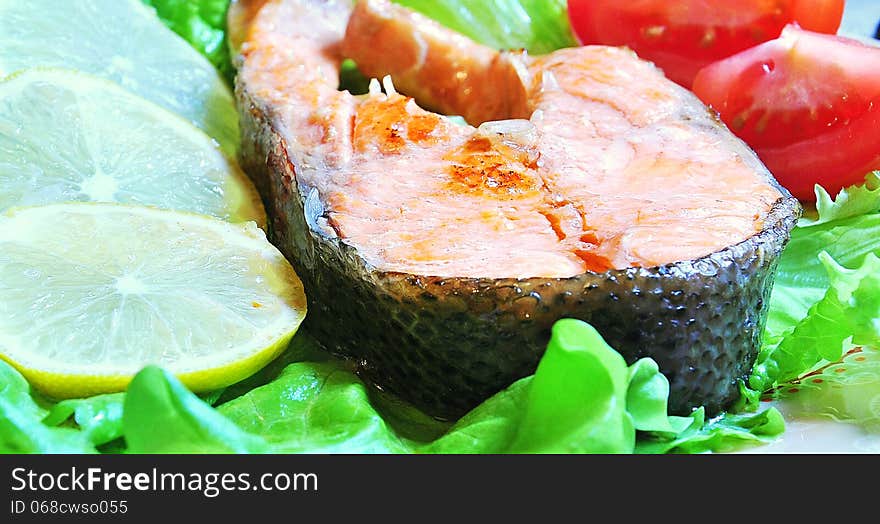 Grilled trout with tomato, lemon, lettuce. Grilled trout with tomato, lemon, lettuce