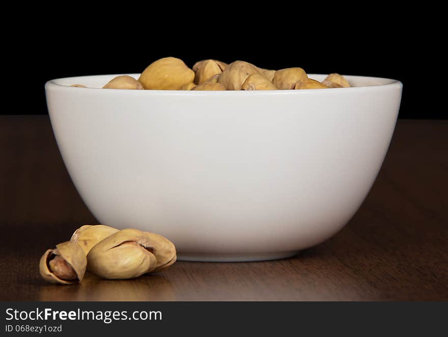 Dry salted pistachio fruit in bowl on the table. Dry salted pistachio fruit in bowl on the table.