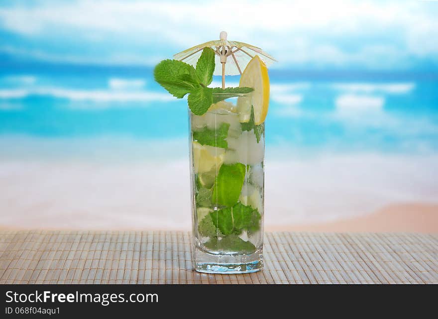 Mojito cocktail on a bamboo cloth, against the sea