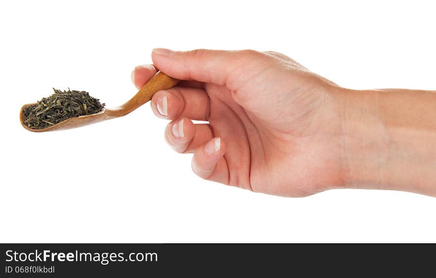 Wooden spoon with green tea, in the female hand, isolated on white. Wooden spoon with green tea, in the female hand, isolated on white