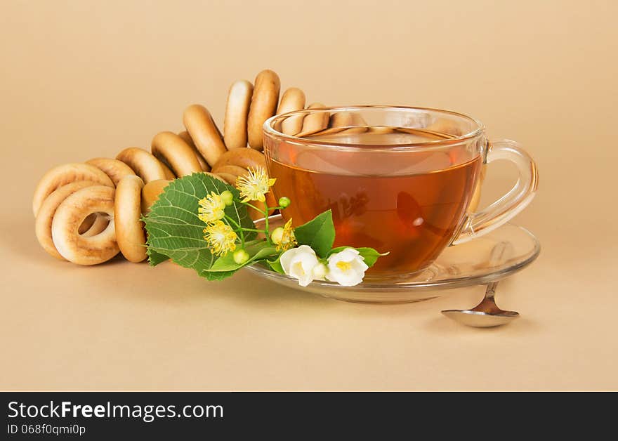 Cup of tea, bagels, linden and jasmine flowers, on a beige background