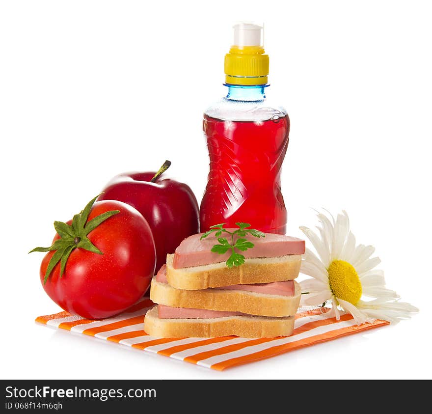 Sandwiches, tomato, red apple, camomile and bottle with compote, on a striped napkin, isolated on white. Sandwiches, tomato, red apple, camomile and bottle with compote, on a striped napkin, isolated on white