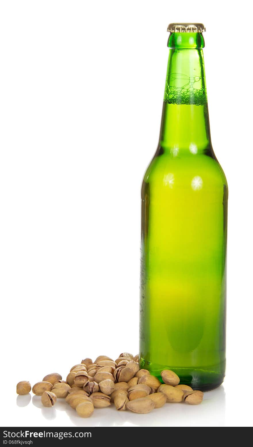 Bottle of beer and the fried pistachios isolated on white. Bottle of beer and the fried pistachios isolated on white