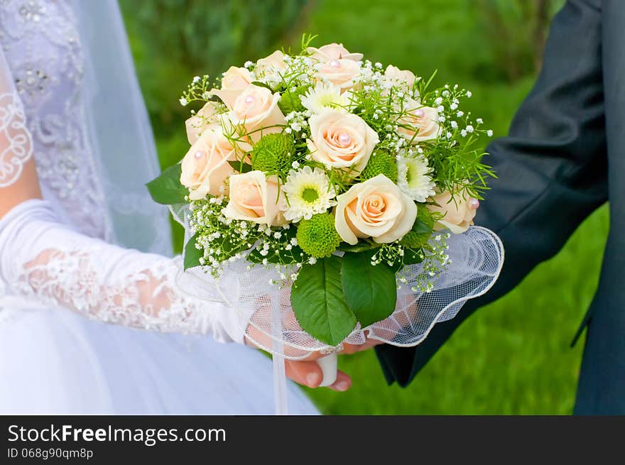 Wedding theme, hands and rings on wedding bouquet