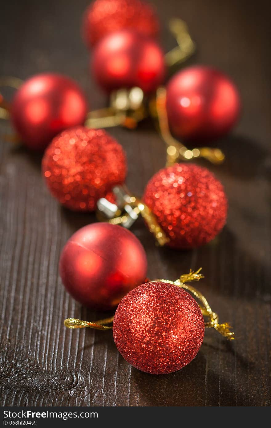 Small red Christmas balls on a wooden table