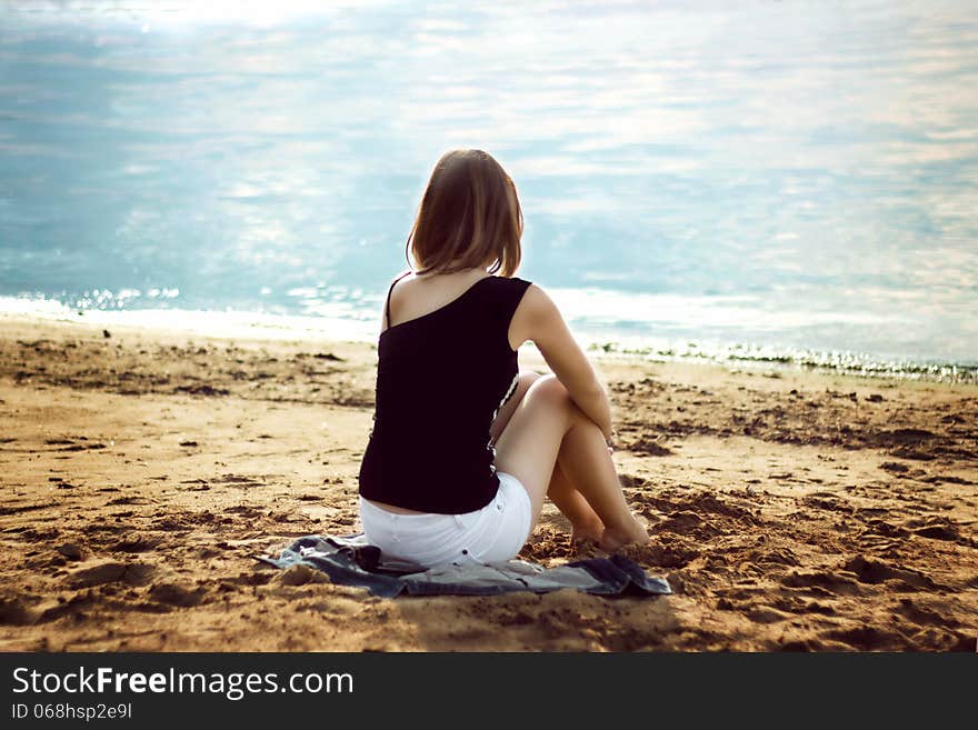 Lonely girl relaxing on the sea beach