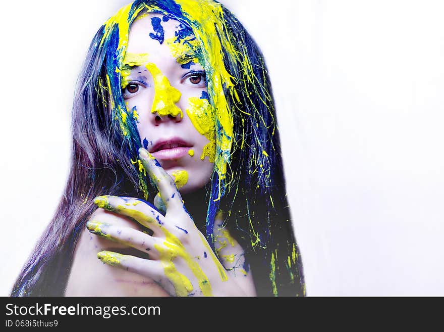 Beauty portrait of woman painted blue and yellow on white background