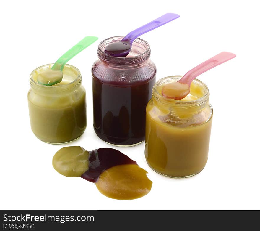 Three baby food jars with spoons isolated