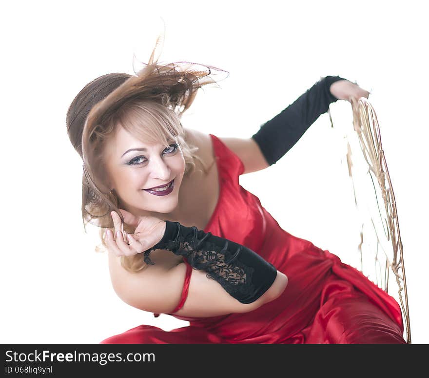 Woman in a red dress posing on a chair on a white background