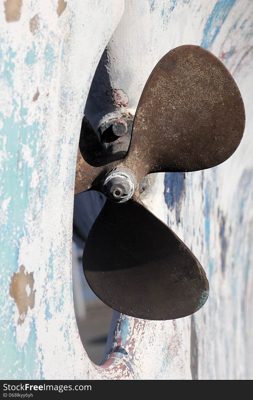 Rusty boat propeller in a dry dock.