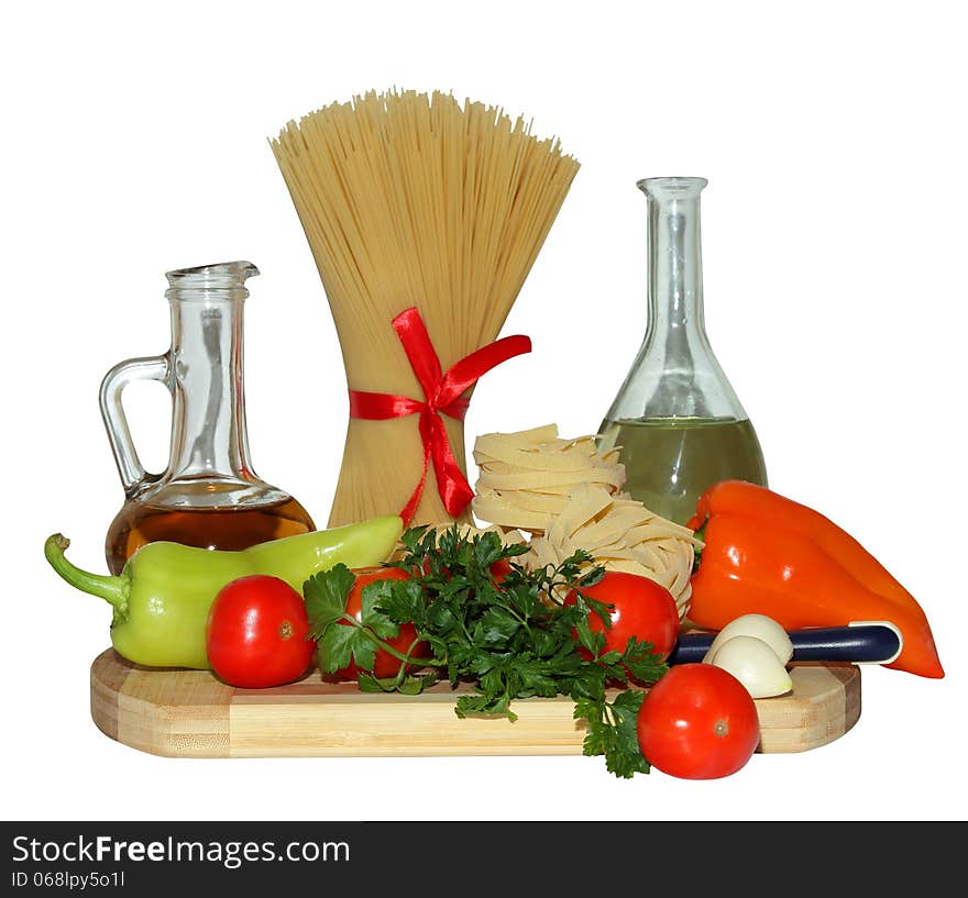 Pasta, tomatoes, pepper,greens and olive oil on a cutting board