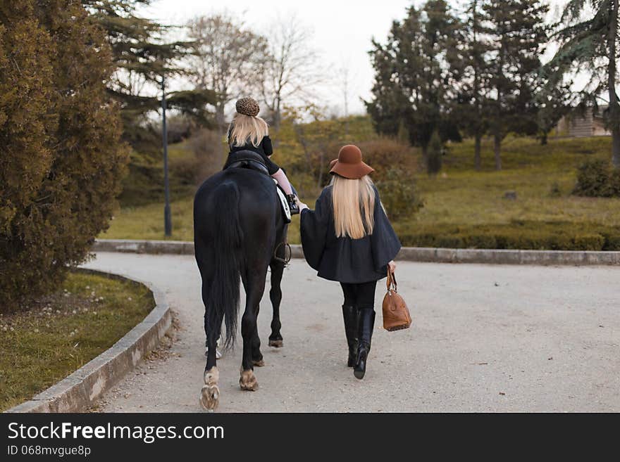 Happy family with black horse in the park