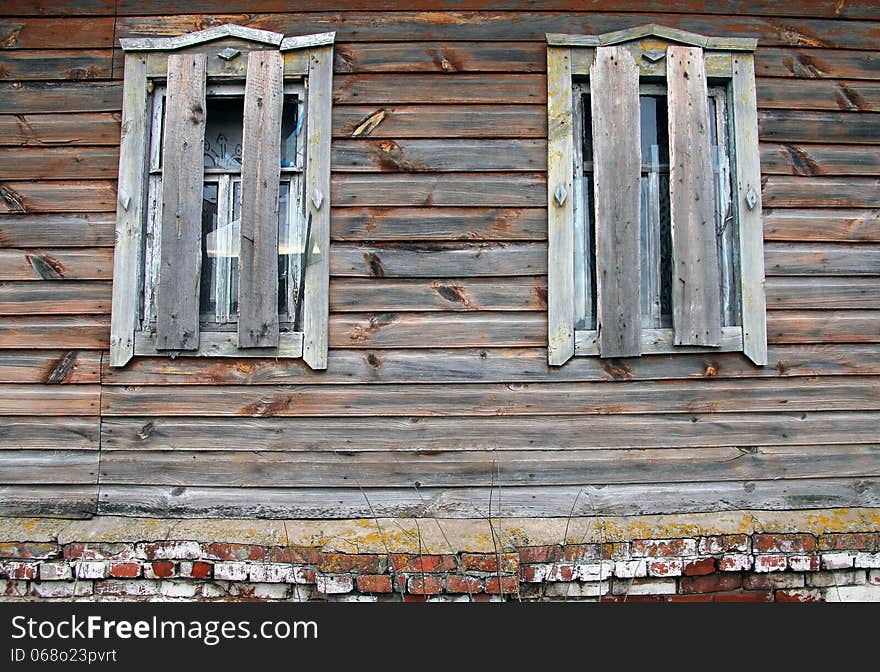 Broken And boarded windows of an old abandoned farmhouse