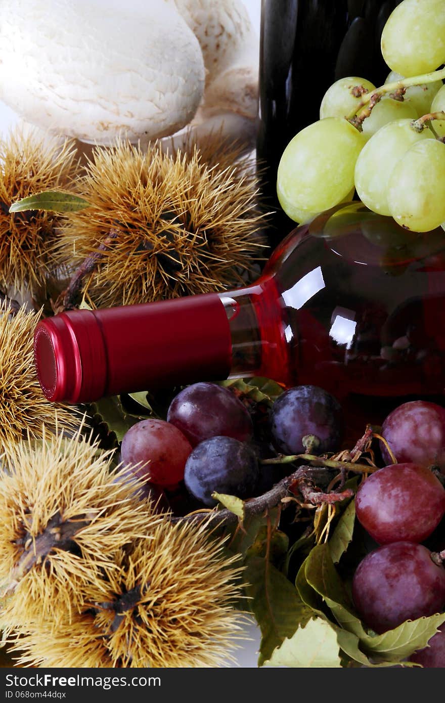 Rose wine with grapes and chestnuts and mushrooms in the foreground out of focus