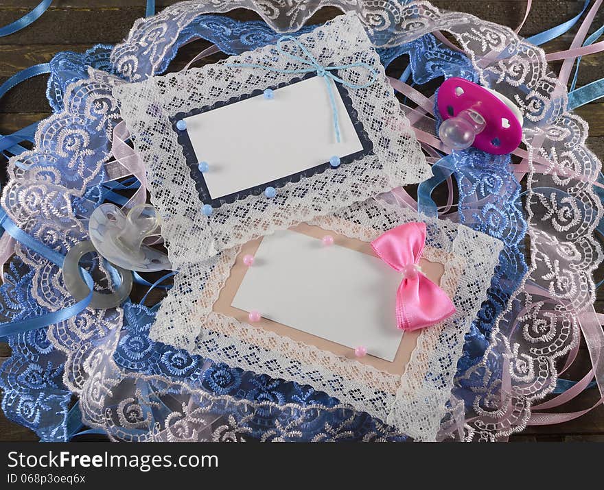 Two greeting cards with two pacifiers on wooden background. Two greeting cards with two pacifiers on wooden background