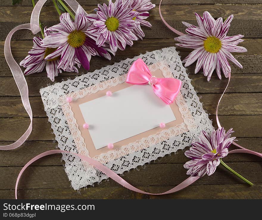 Pink greeting card with flowers on wooden background. Pink greeting card with flowers on wooden background