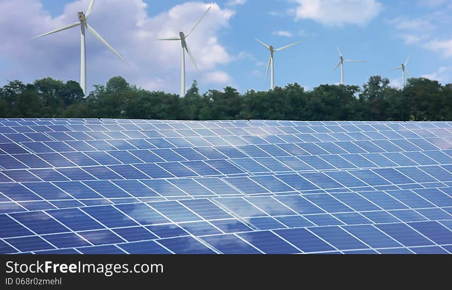 In the foreground - solar power. In the background - wind power. Clouds are running quickly - timelapse. In the foreground - solar power. In the background - wind power. Clouds are running quickly - timelapse