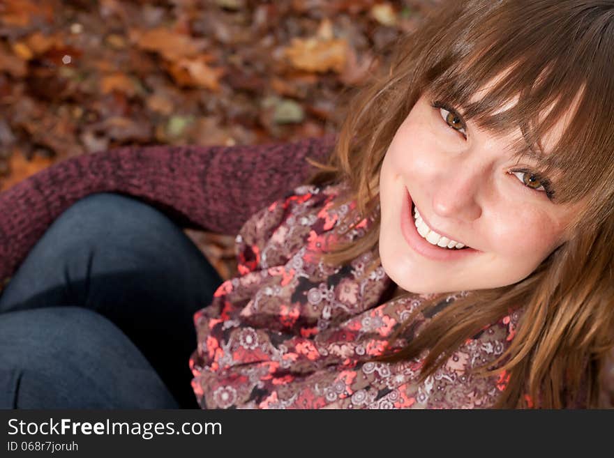 Smiling girl on the autumn ground