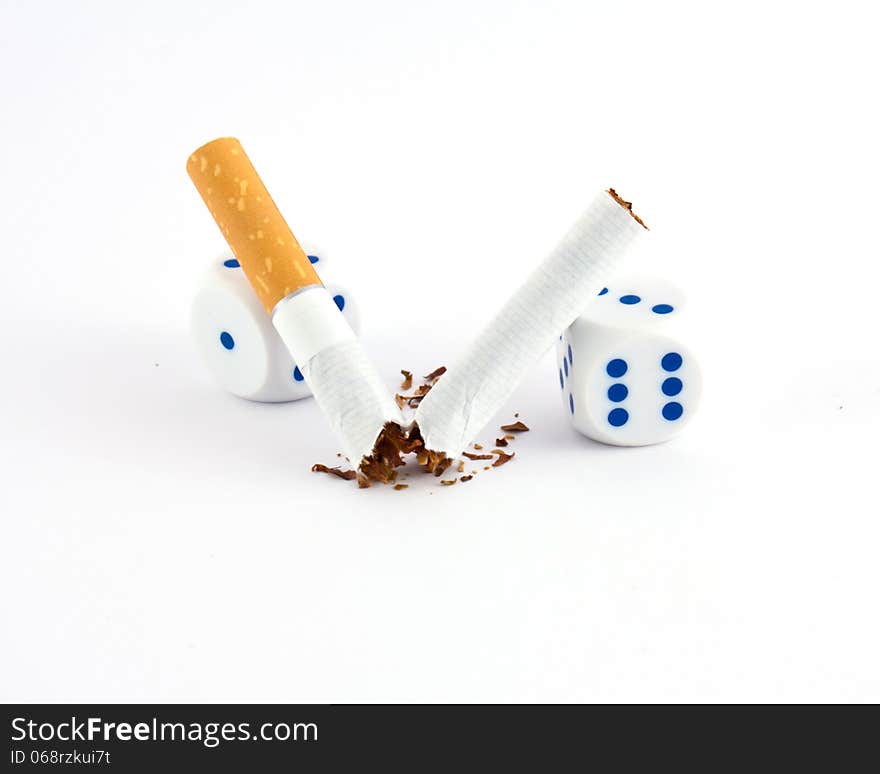 Broken cigarette with two dices. Broken cigarette with two dices